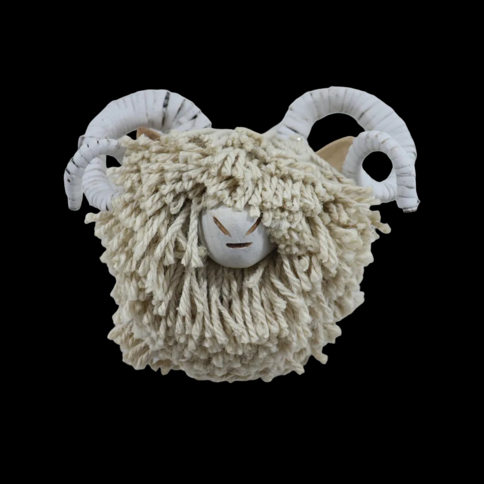 A rustic sheep head wall hanging with shaggy cream wool and white ram horns, mounted on a plain white wall.