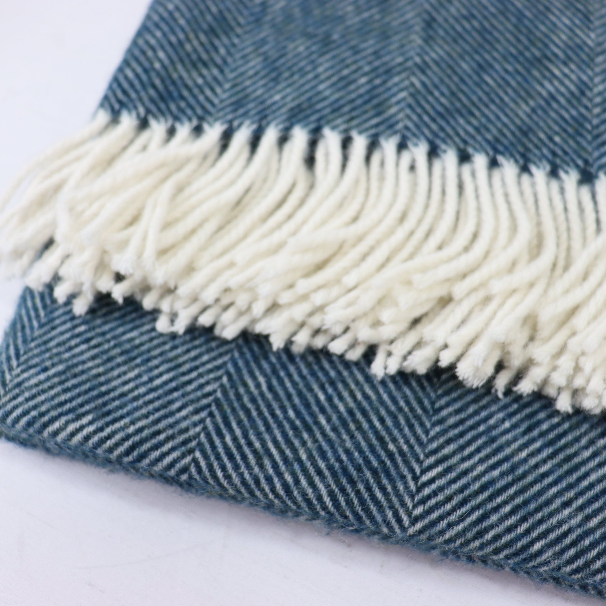Teal fabric with white fringe on a white background