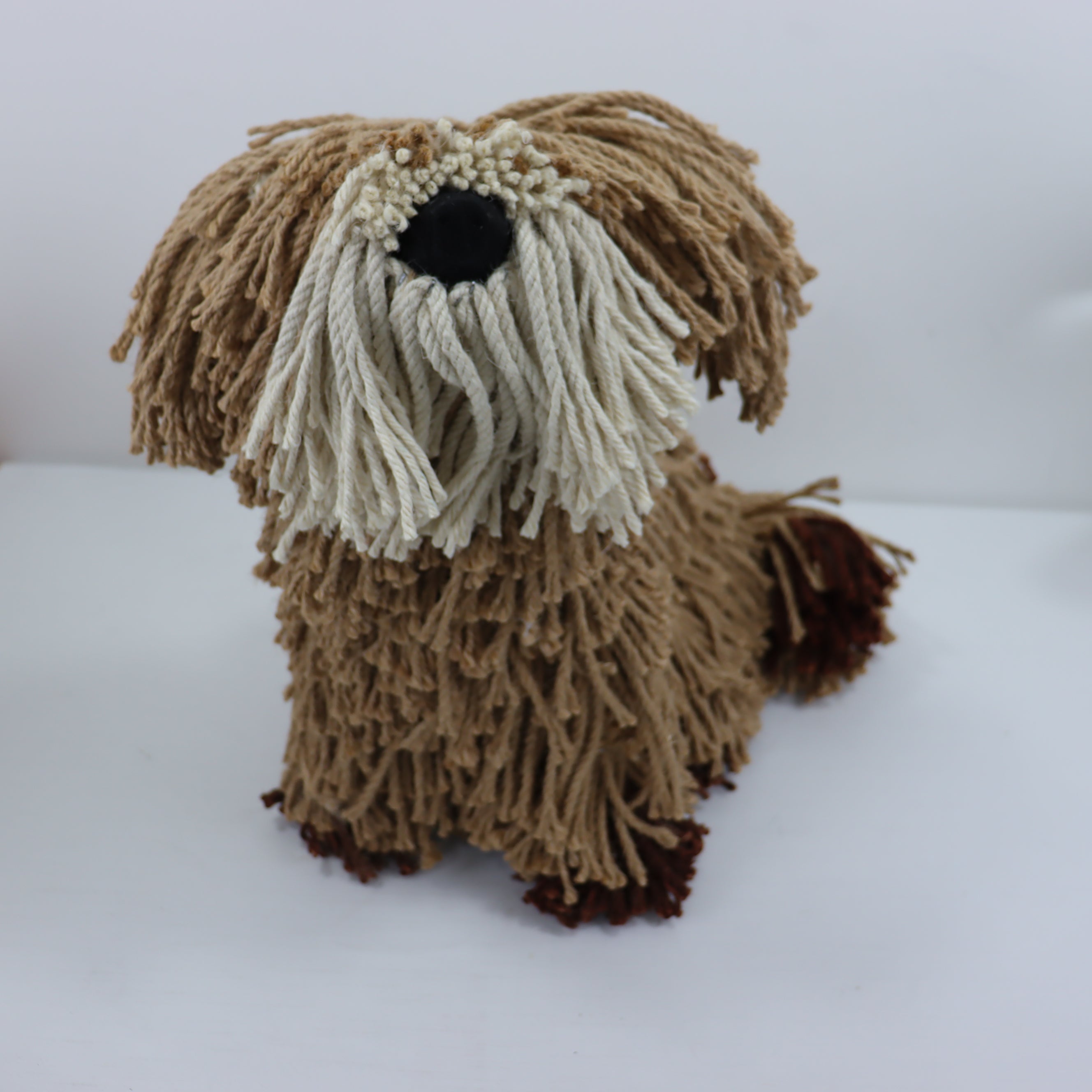 Knitted dog toy with brown and beige fur on a white background