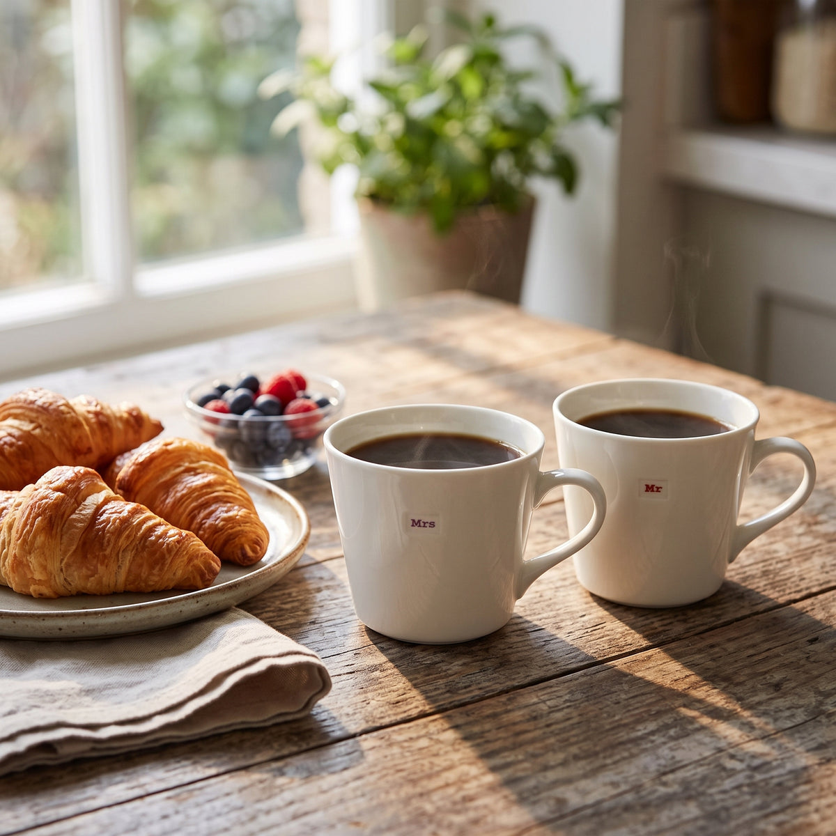 Two white ceramic coffee mugs with small red &