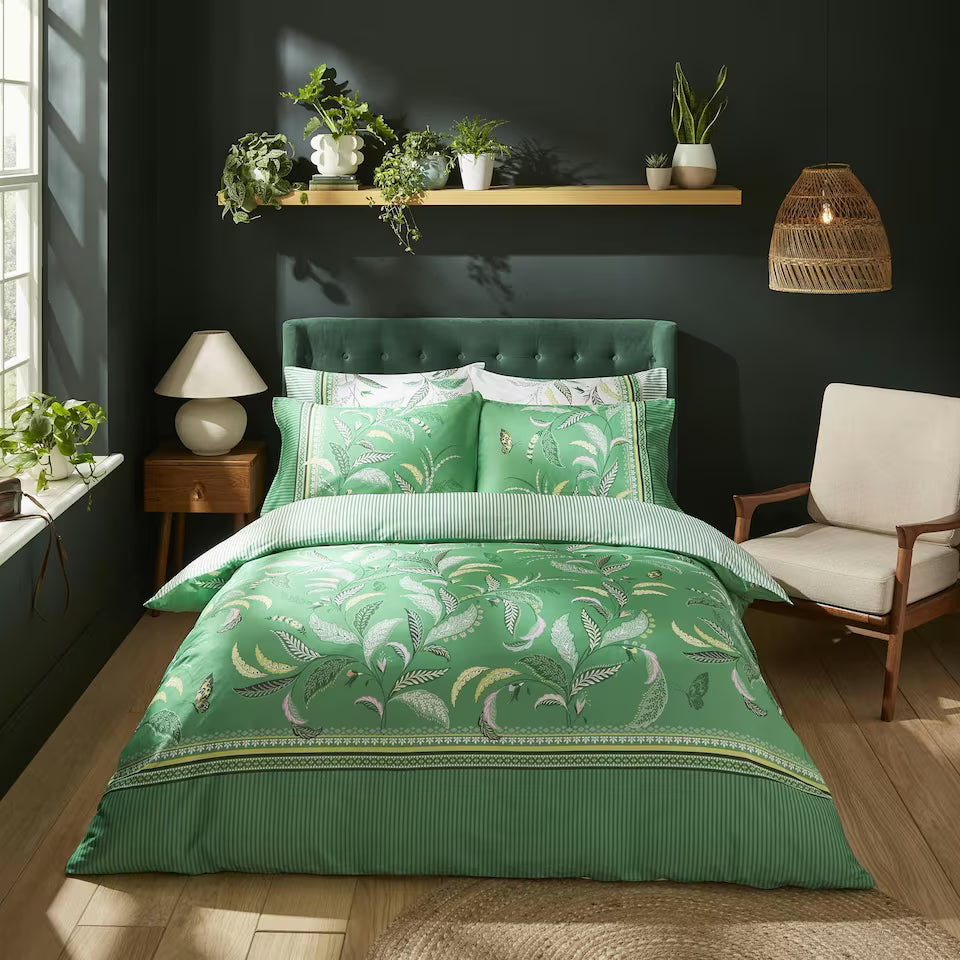 a green bed with pillows and a chair