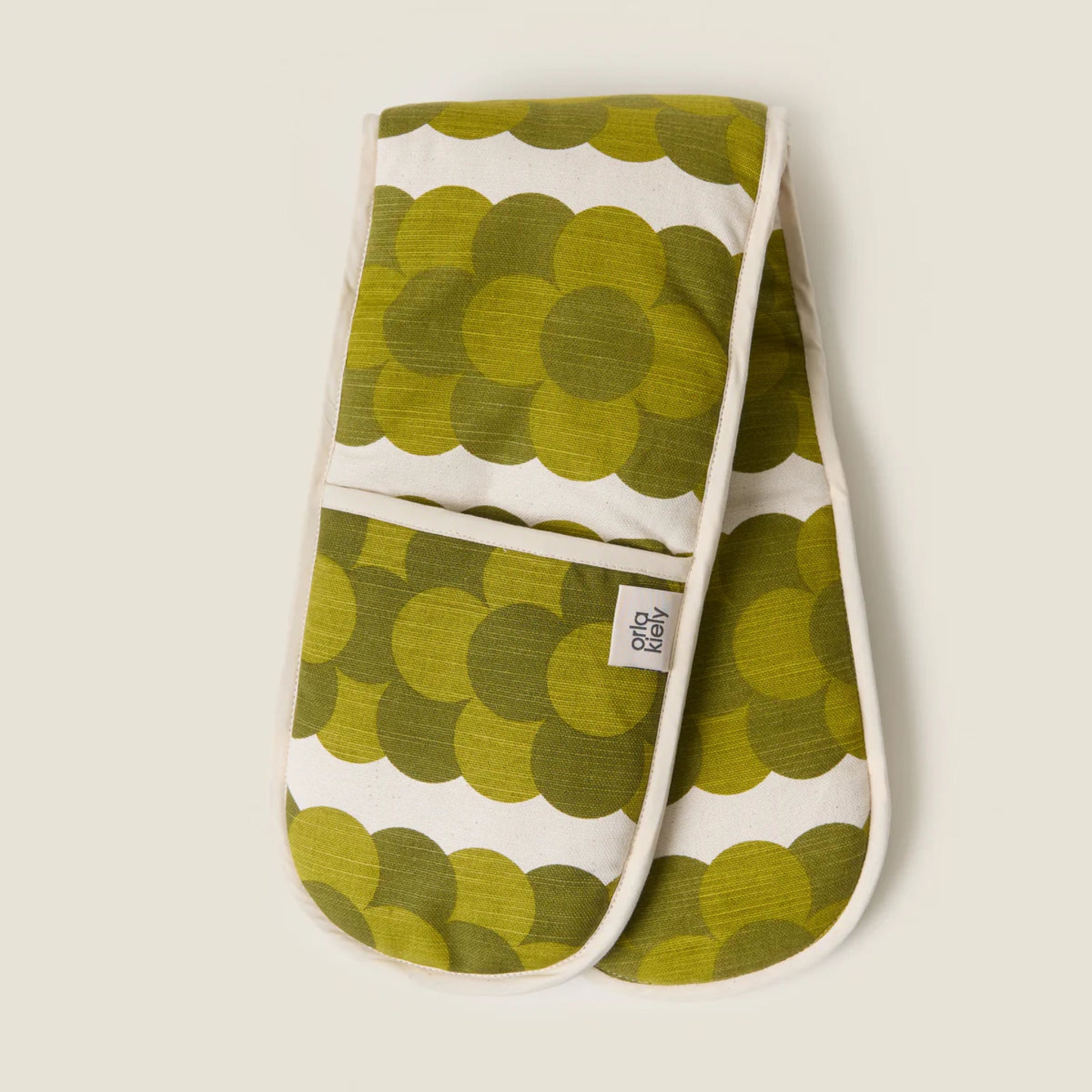 Pair of green patterned oven mitts on a beige background