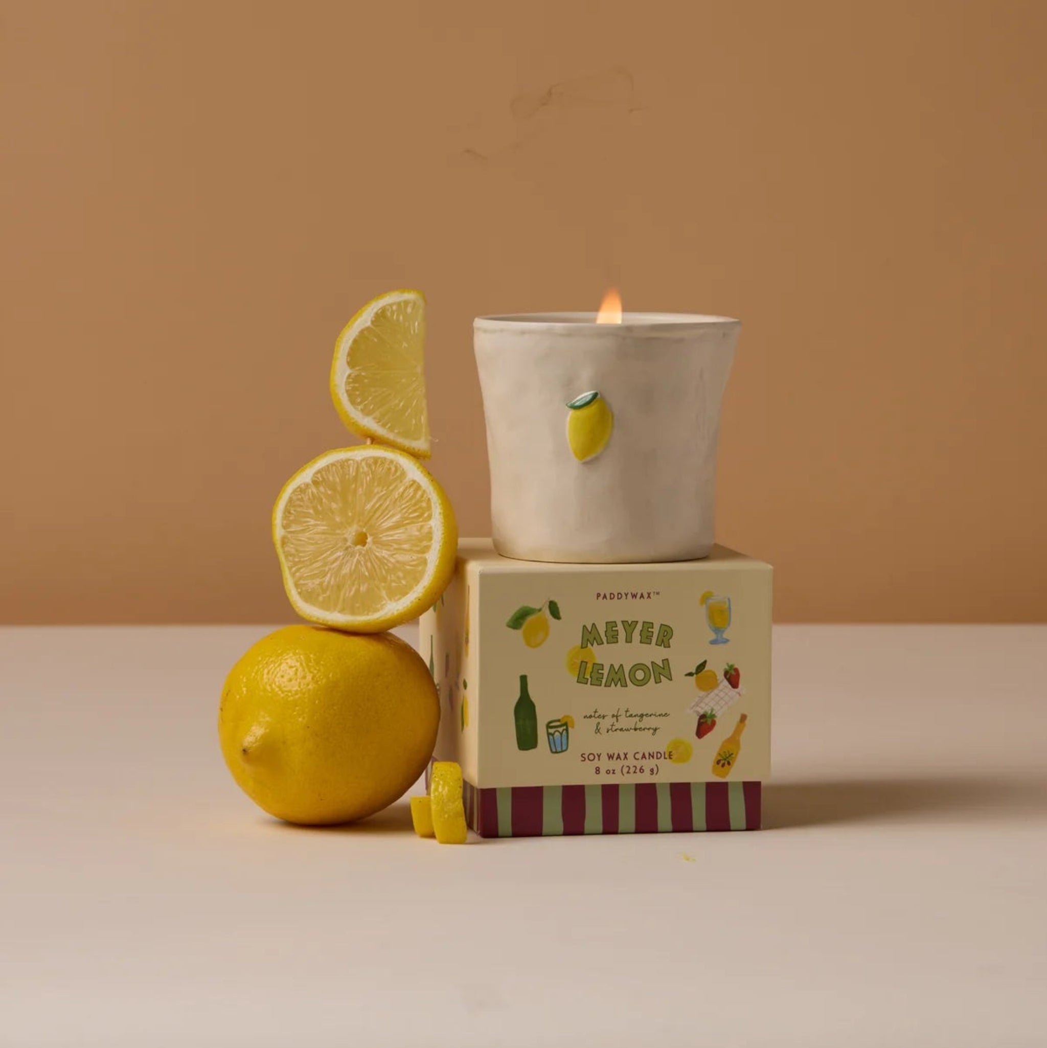 Candle with lemon design on a brown background
