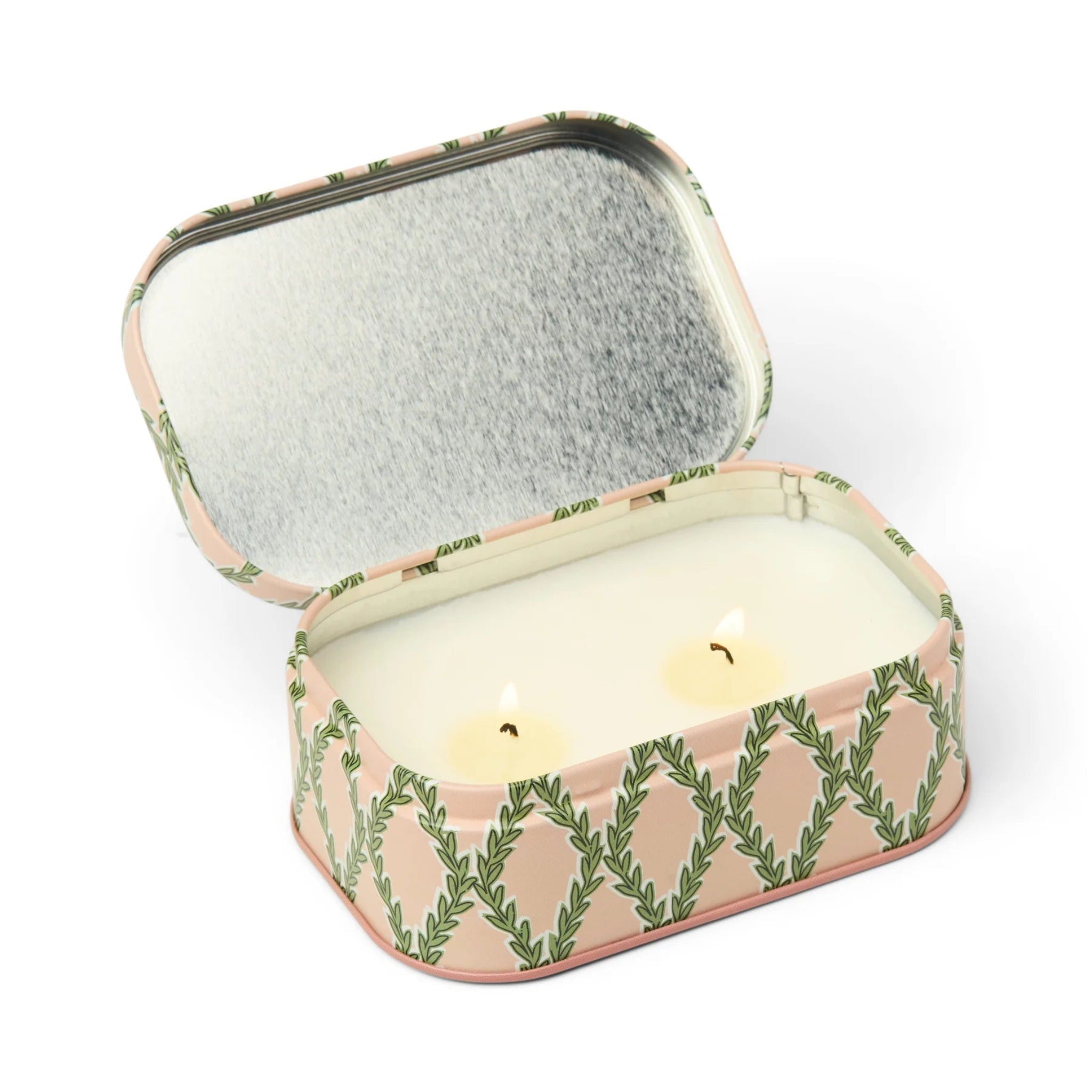 Decorative candle in a tin with a leaf pattern on a white background