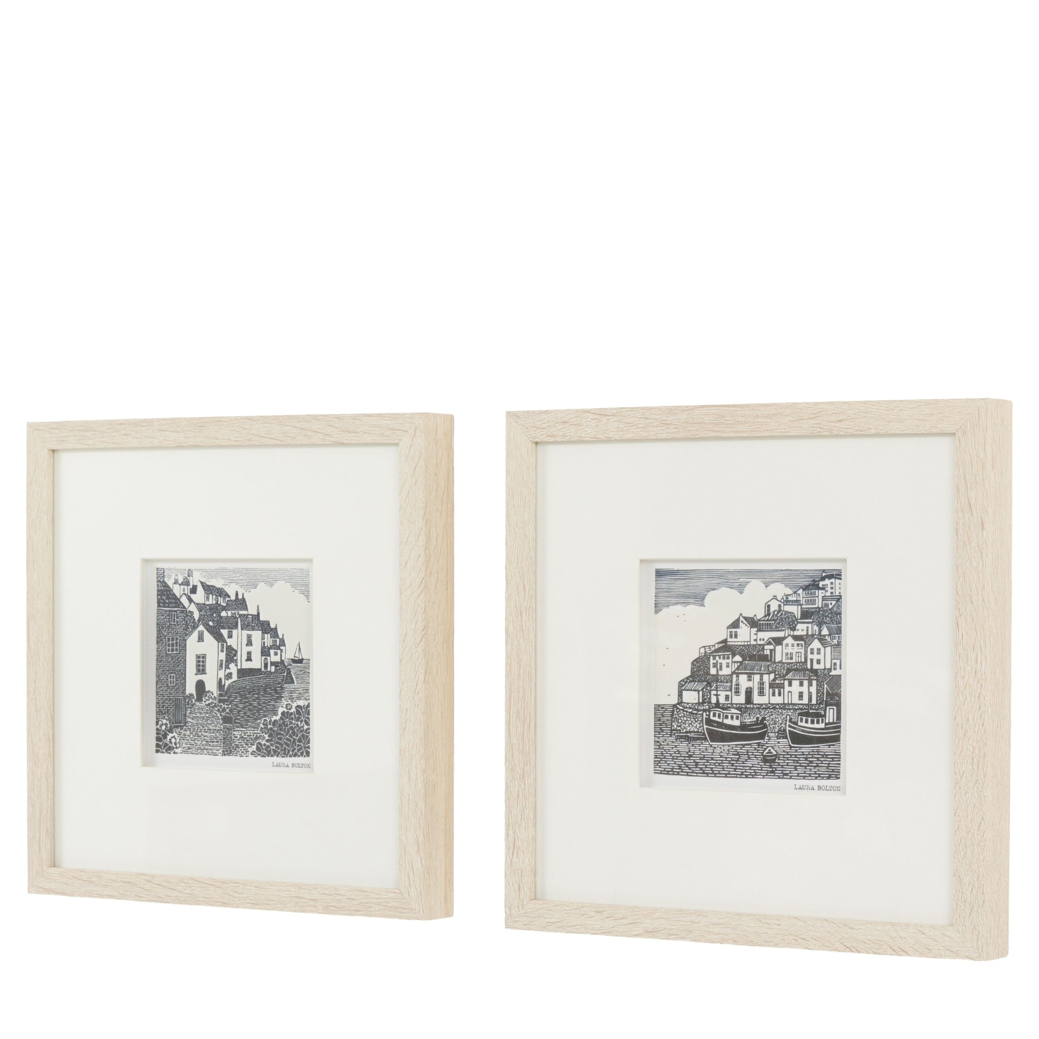 Two framed black and white prints of coastal scenes on a white background