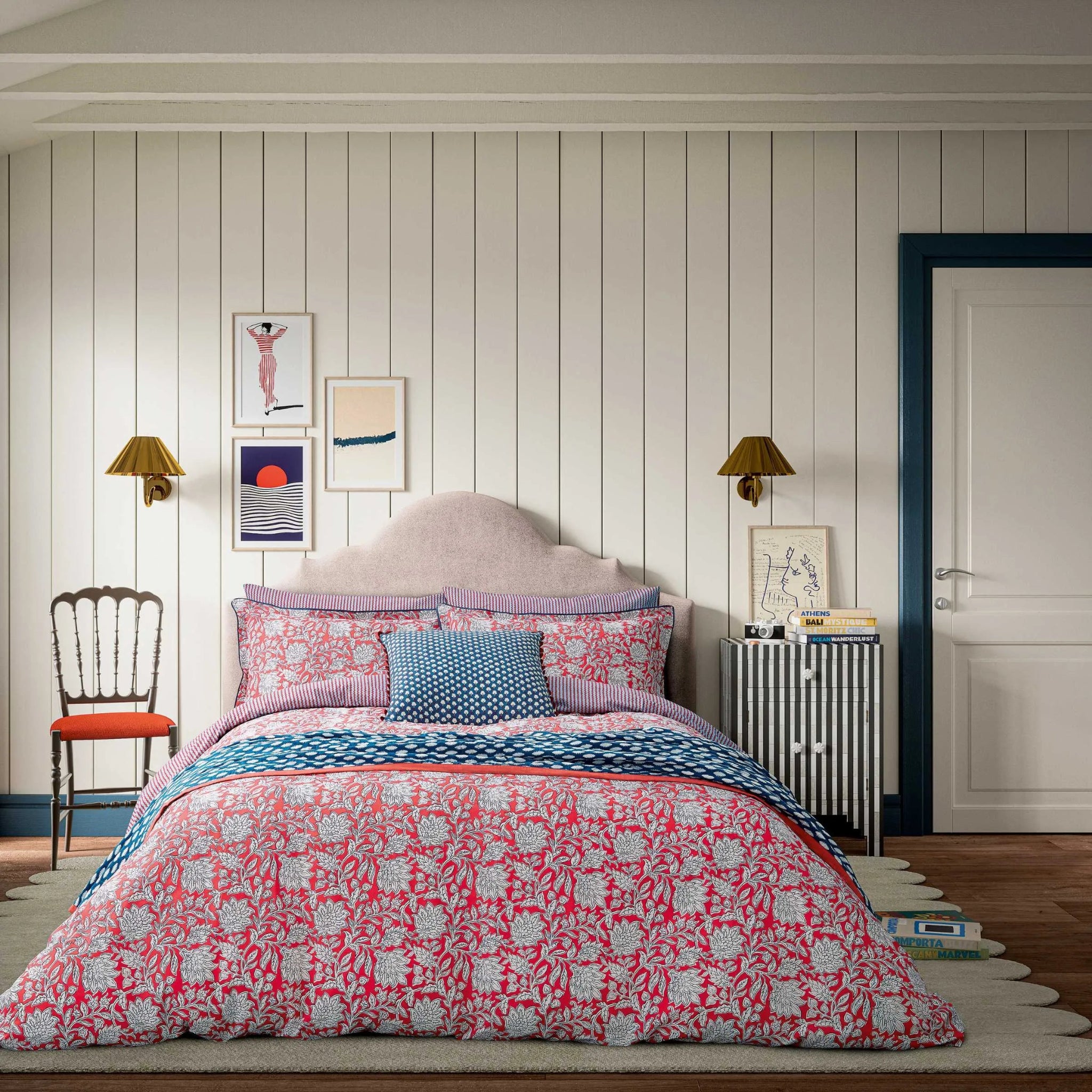 Bedroom with floral bedding and decorative pillows on a bed.