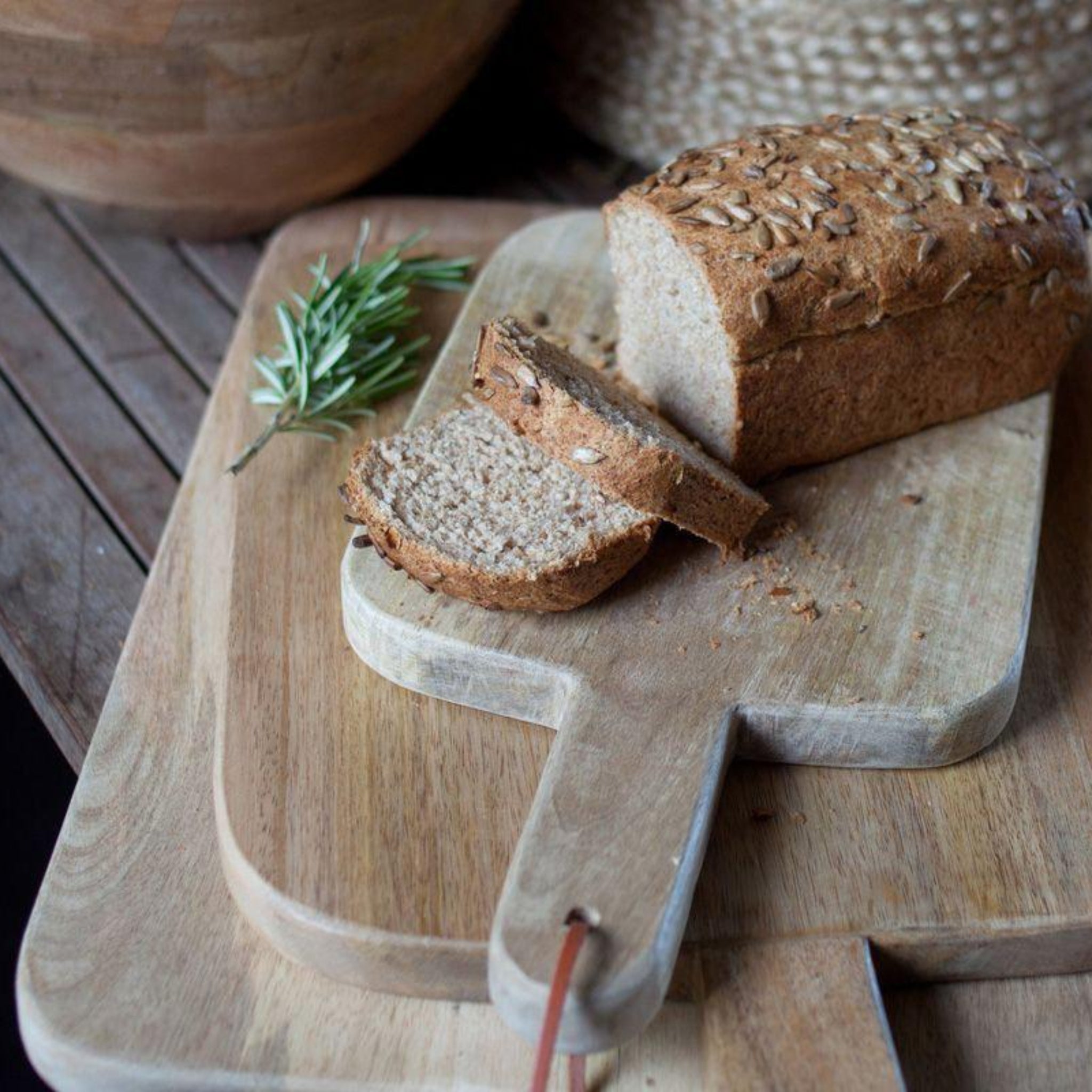 Loaf of bread with slices on a wooden cutting board with a rustic background