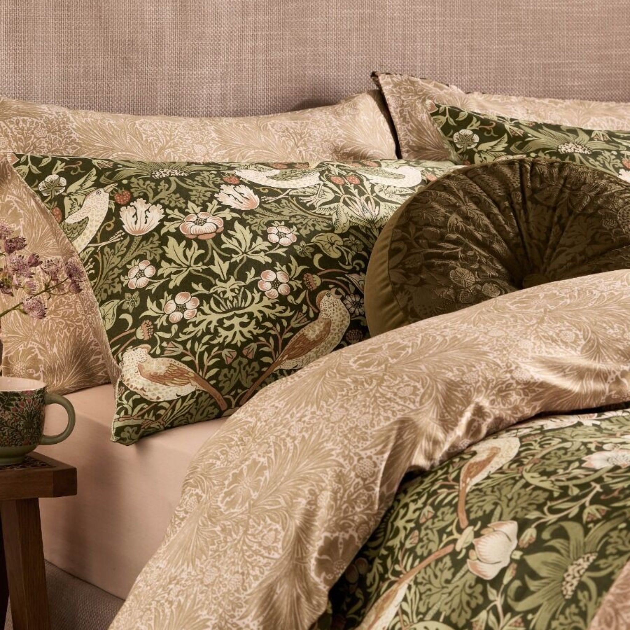 Floral and bird patterned bedding with a textured headboard.