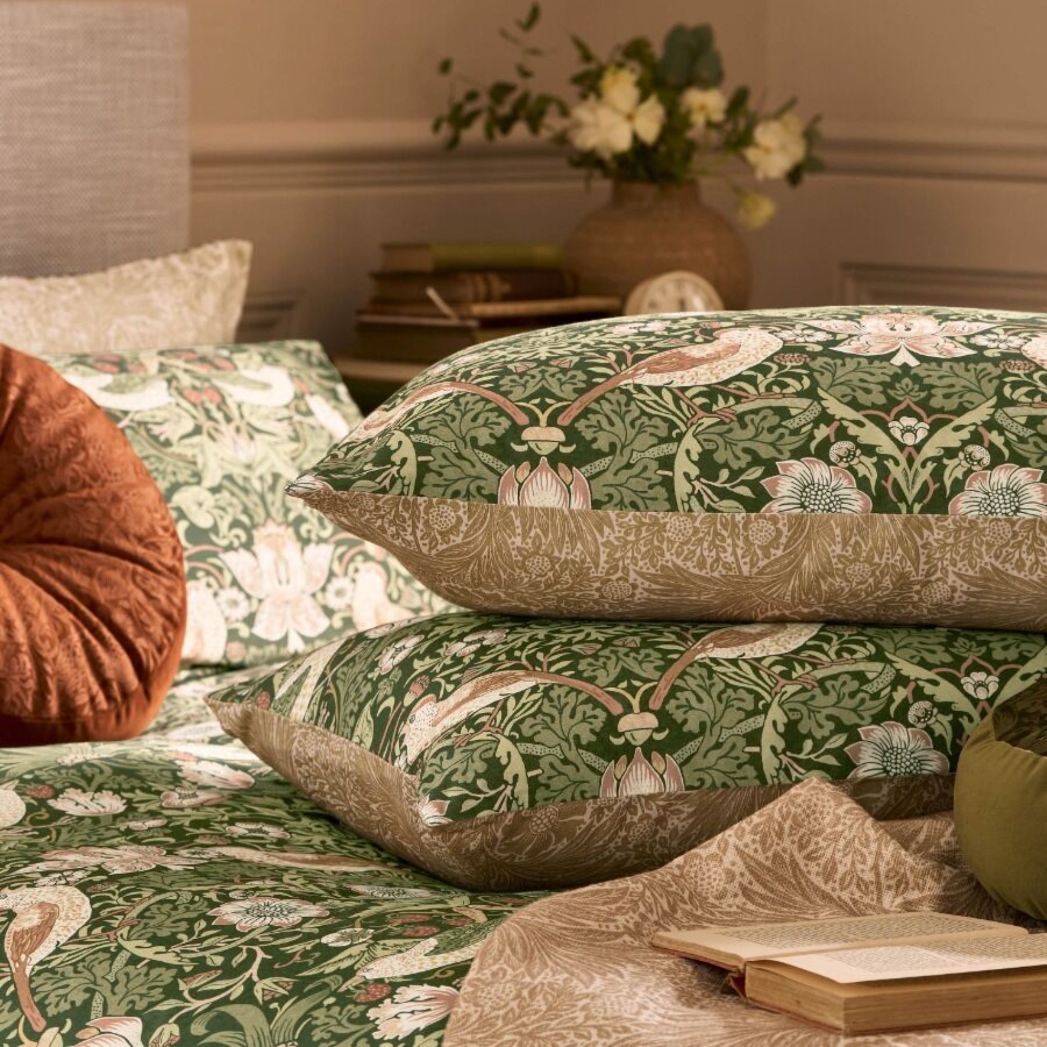 Floral patterned bedding with a vase of flowers on a bed in a bedroom setting.