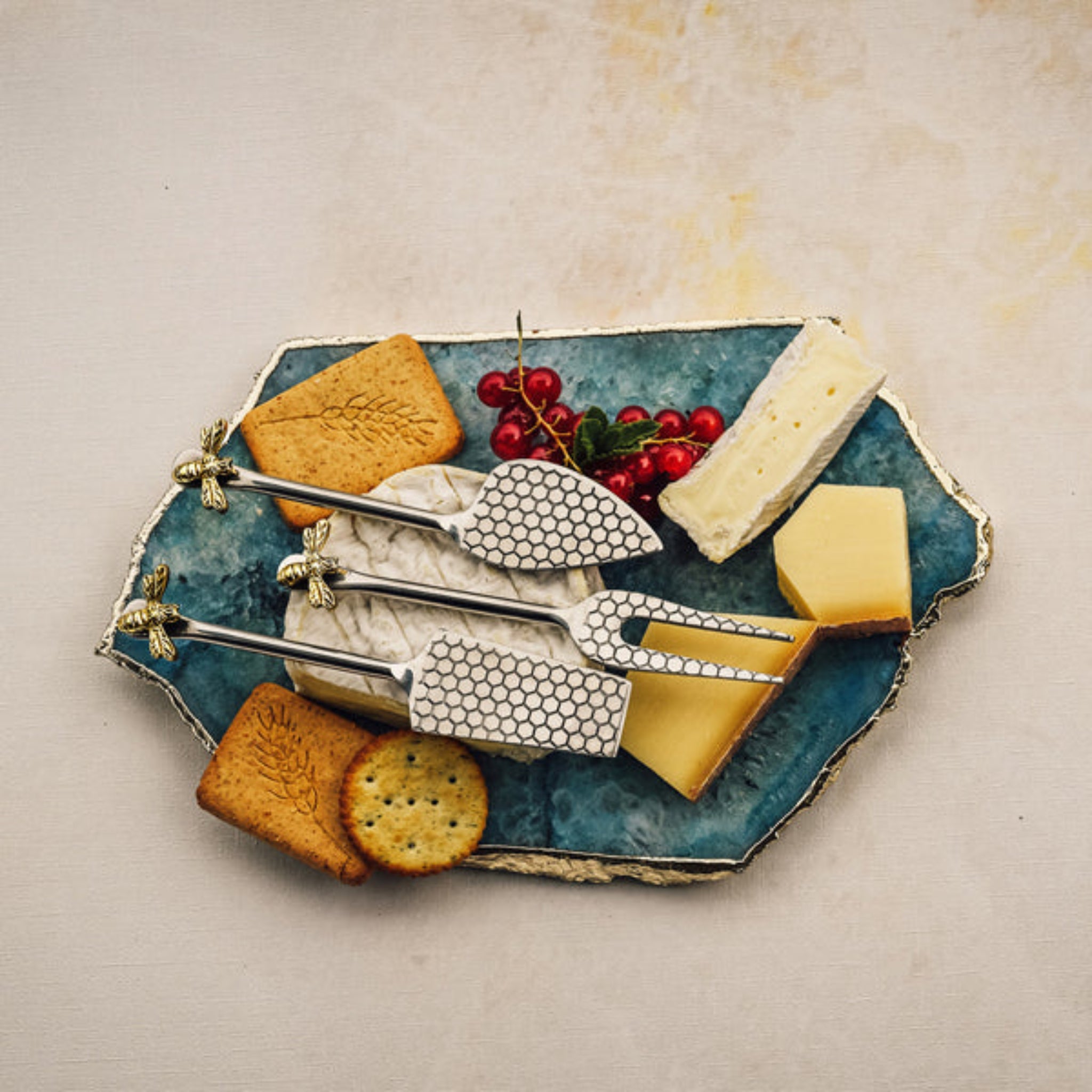 Cheese platter with cheese, crackers, and fruit on a textured surface