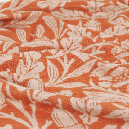 Close-up of orange fabric with white floral pattern