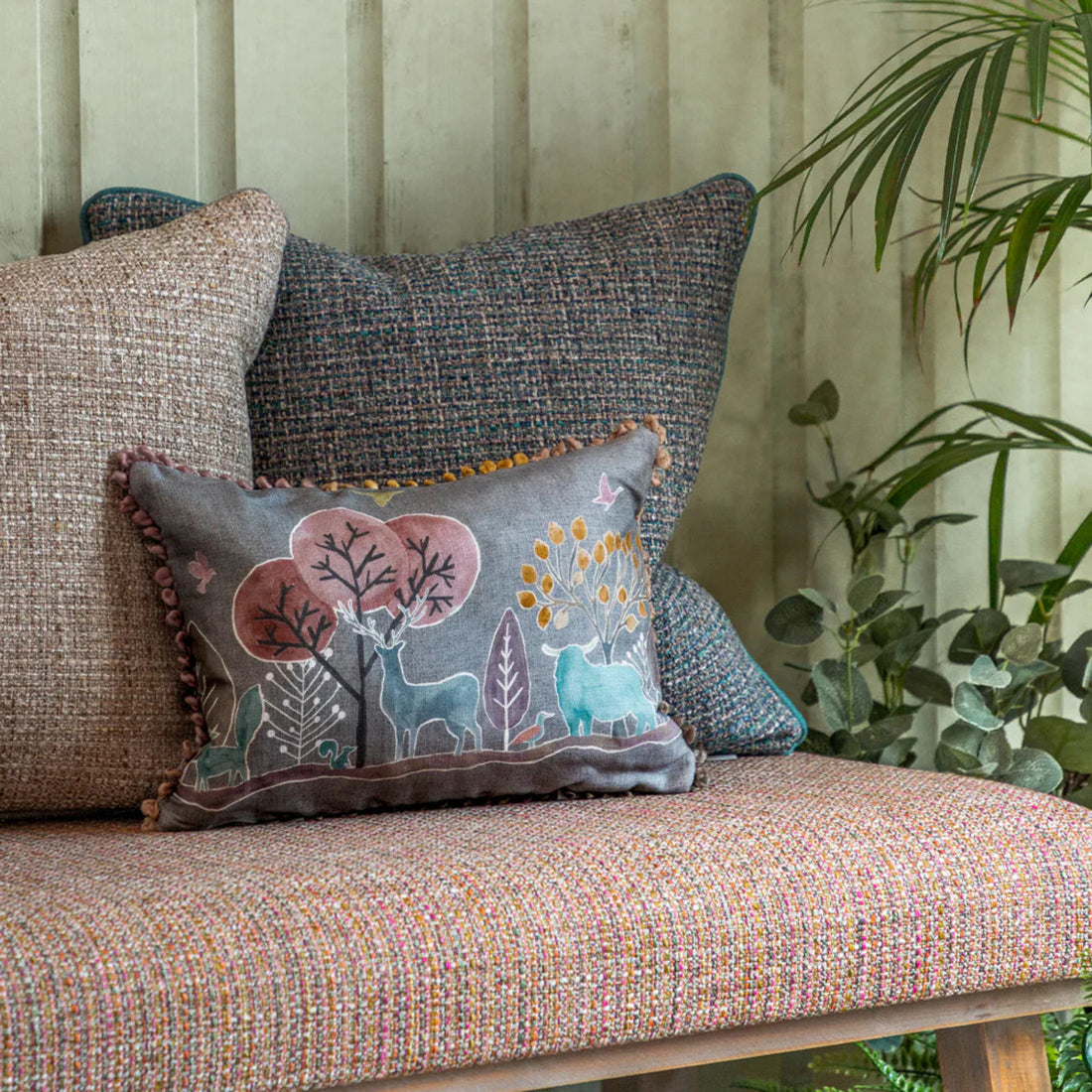 Decorative pillow with animal design on a textured sofa with plants in the background