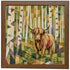 A framed square art print featuring a geometric, low-poly style illustration of a Highland cow standing in a birch forest. The artwork uses a rich palette of greens, yellows, browns, and whites, and is enclosed in a medium brown wooden frame.