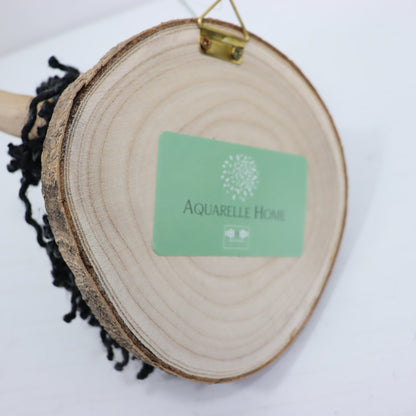 Wooden circular decor item with a green card displaying &