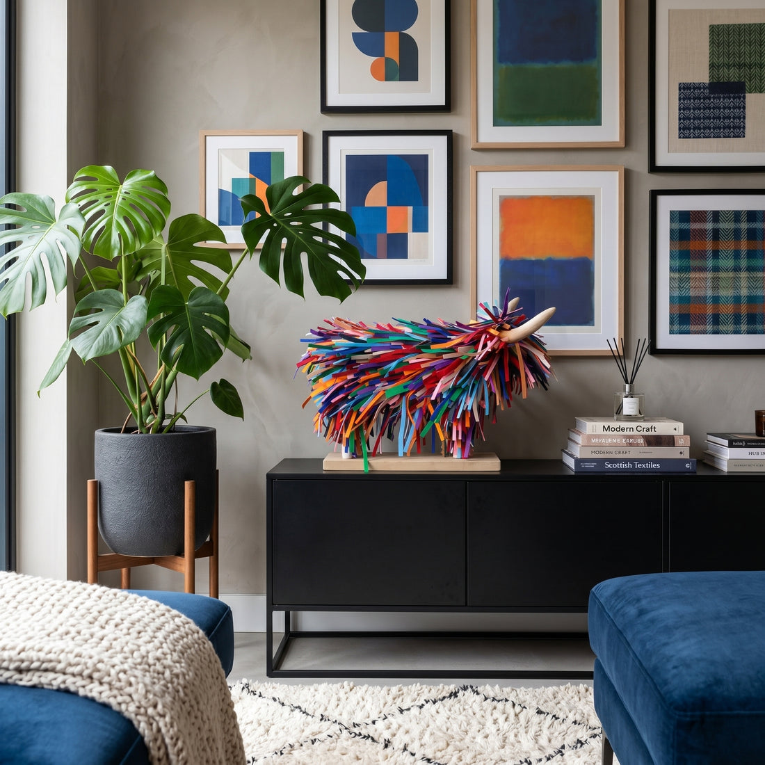 Modern living room with abstract art, a colorful sculpture, and a plant.