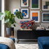 Modern living room with abstract art, a colorful sculpture, and a plant.