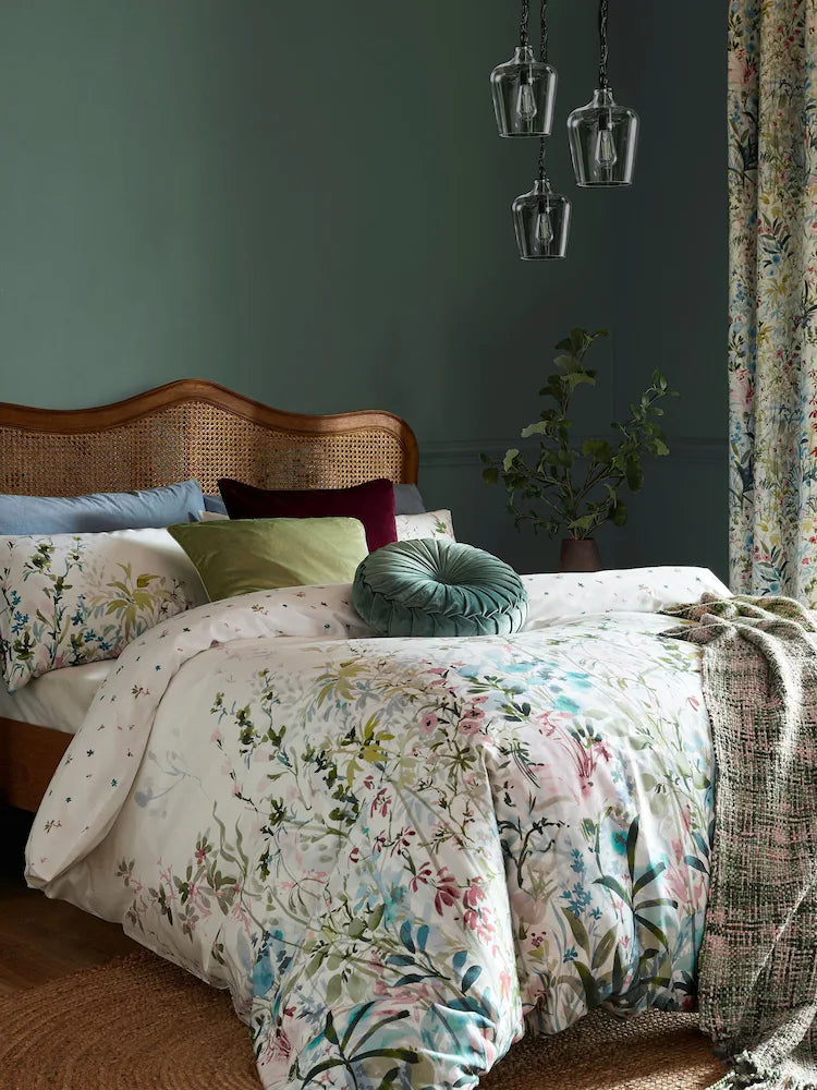 a bed with a floral comforter and pillows