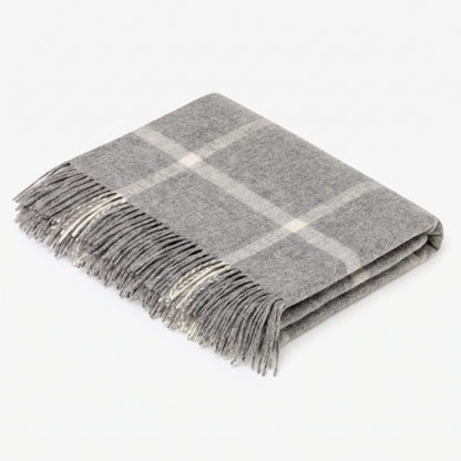A folded gray plaid throw blanket with fringed edges, displayed on a clean white background.