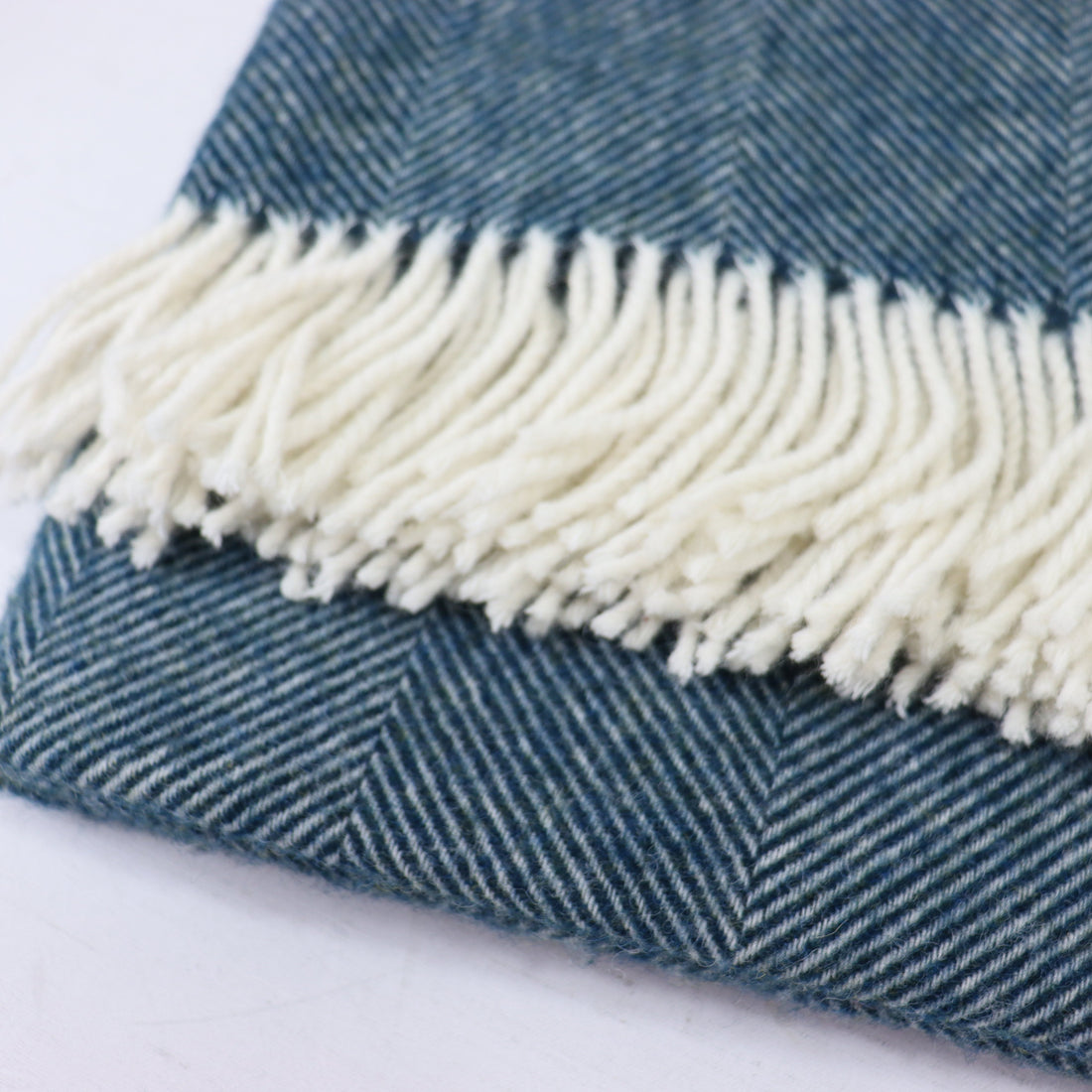 Teal fabric with white fringe on a white background