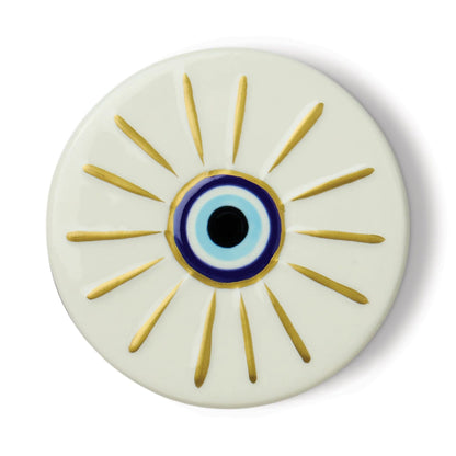 Round ceramic plate with an eye design featuring gold rays on a white background