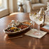 Garnished cocktails with olives and almonds on a wooden table in a cozy room.