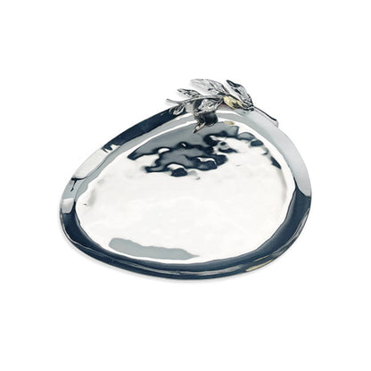 A polished silver-toned metal tray with a hammered texture and a sculpted leaf detail on the rim, shown on a plain white background.