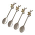 Four silver-toned metal spoons with decorative brass bee and branch handles, arranged diagonally on a white background.