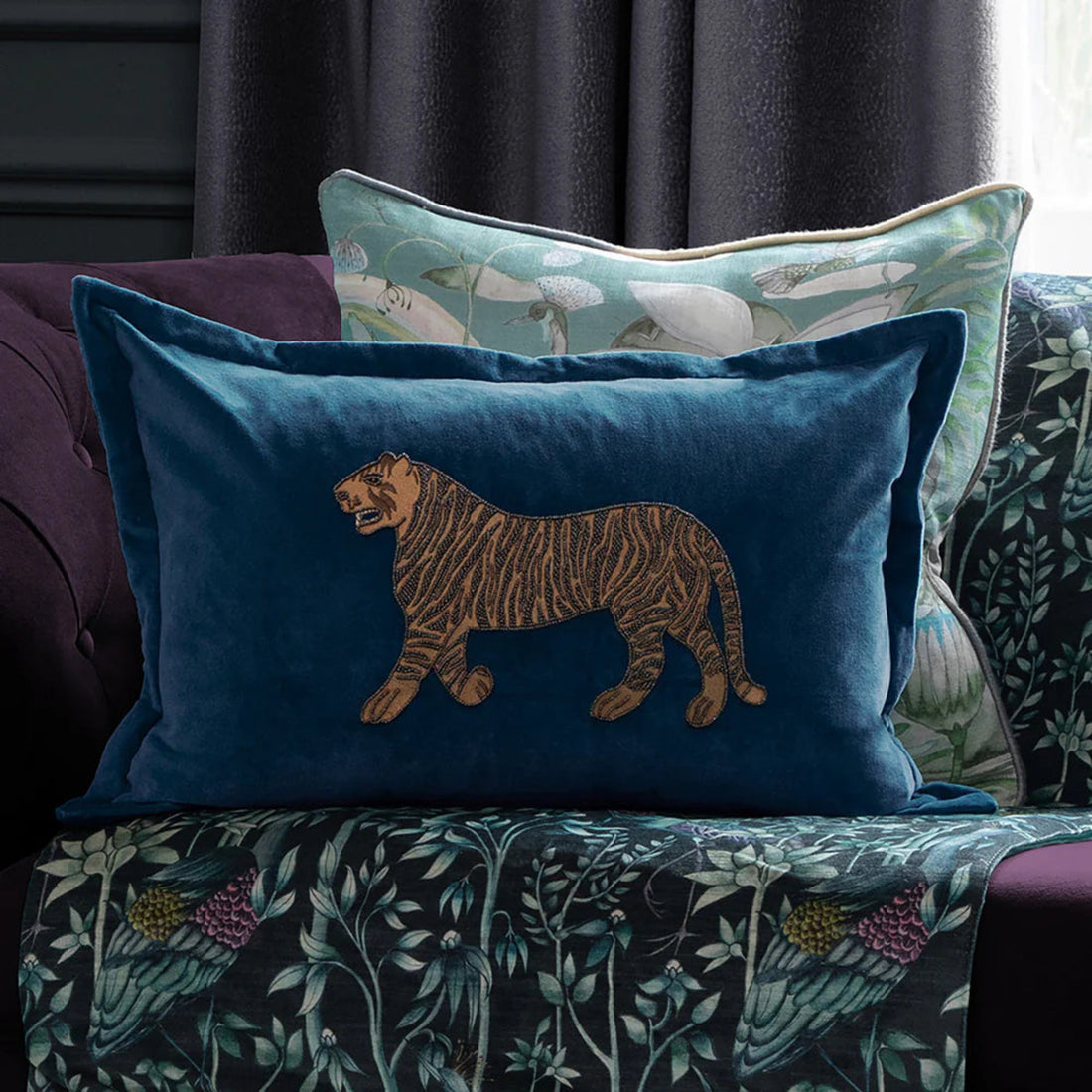 Decorative pillows with a tiger design on a patterned sofa