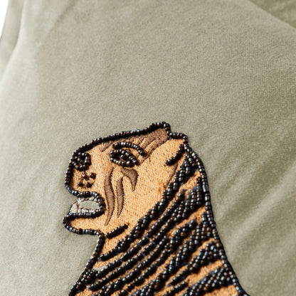 Embroidered tiger design on a beige fabric background