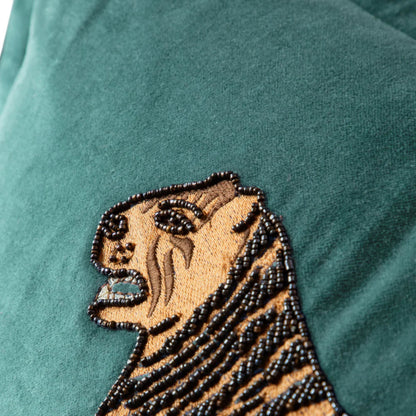 Embroidered tiger design on a teal fabric background