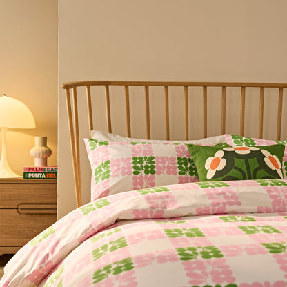 Floral bedding set on a bed with a wooden headboard and lamp.