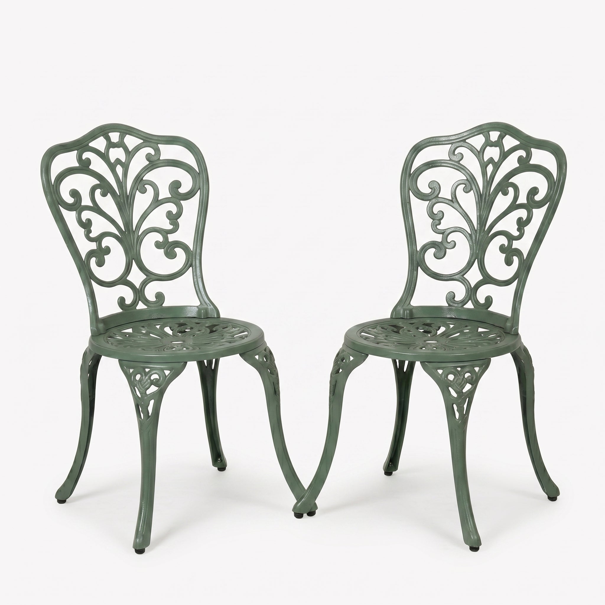 Two green metal chairs with intricate designs on a white background