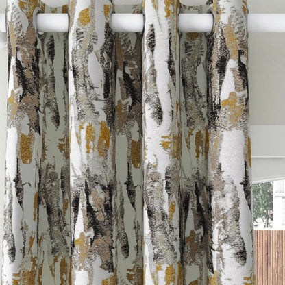 A pair of grommet-top curtains with an abstract birch tree bark pattern in white, gray, black, and gold, hanging on a white rod.
