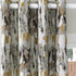 A pair of grommet-top curtains with an abstract birch tree bark pattern in white, gray, black, and gold, hanging on a white rod.