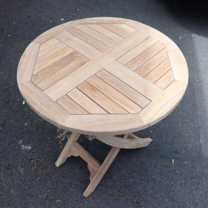 a round wooden table on a sidewalk