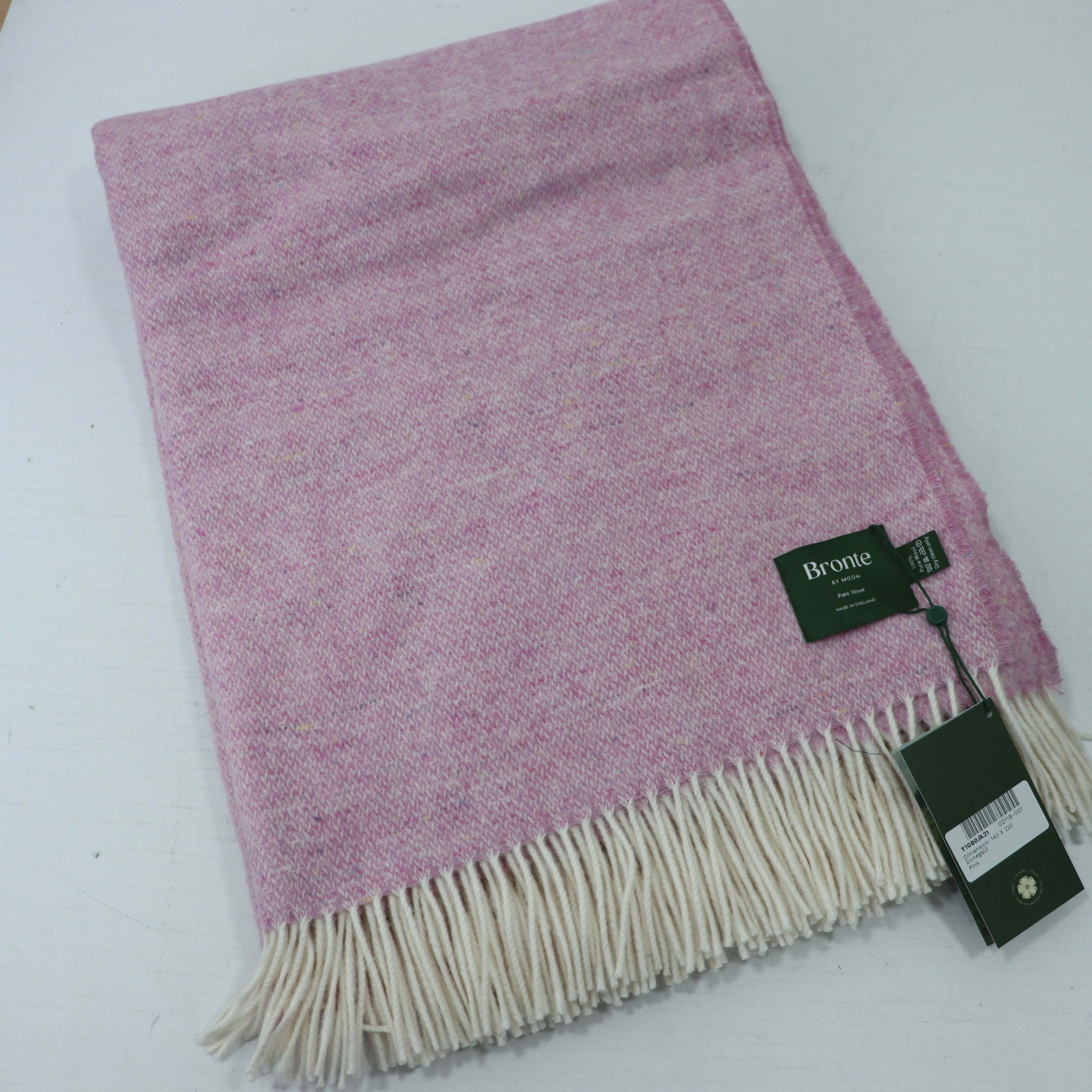 a pink and white blanket with a tag