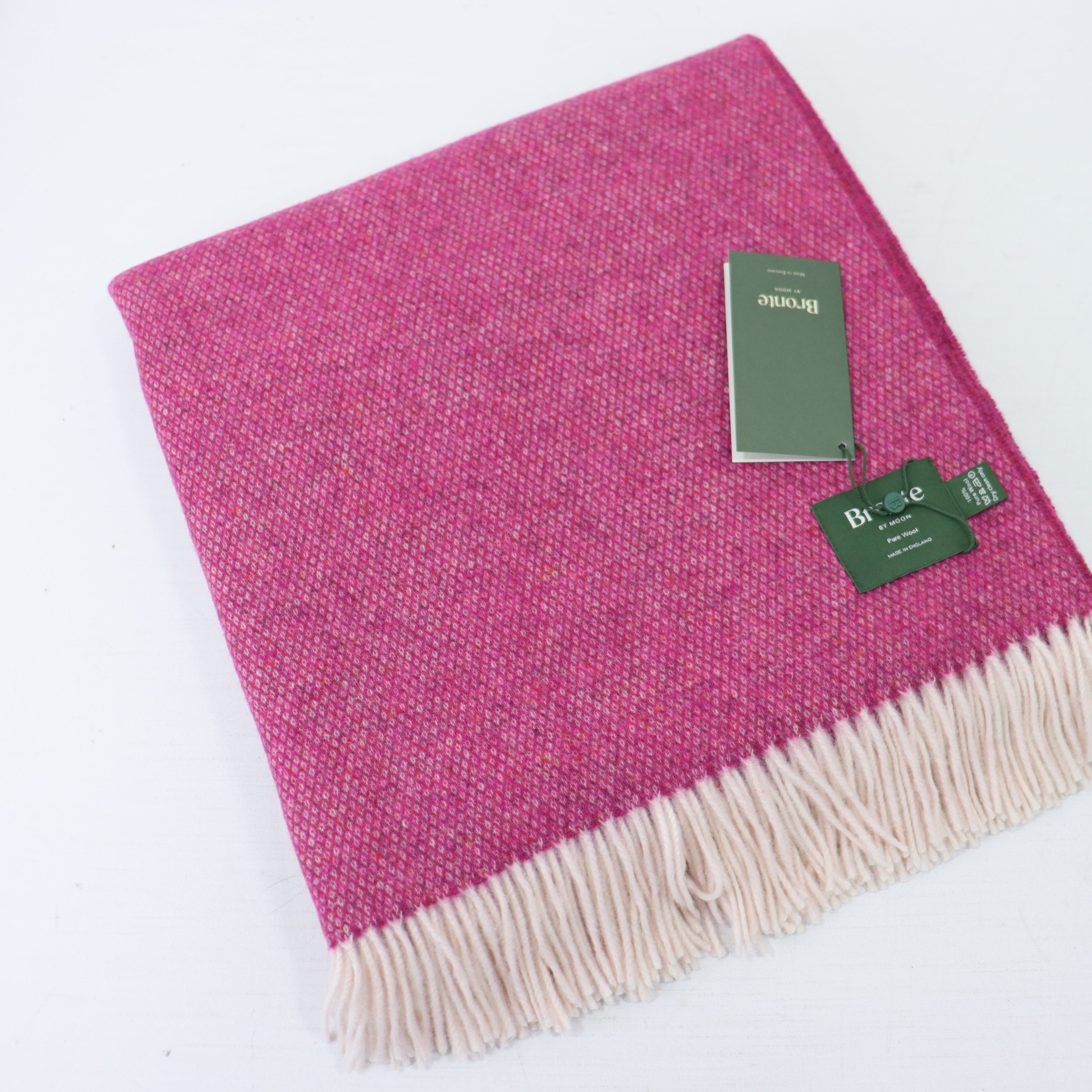 a pink and white blanket with a tag