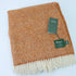 a brown and white blanket with a tag
