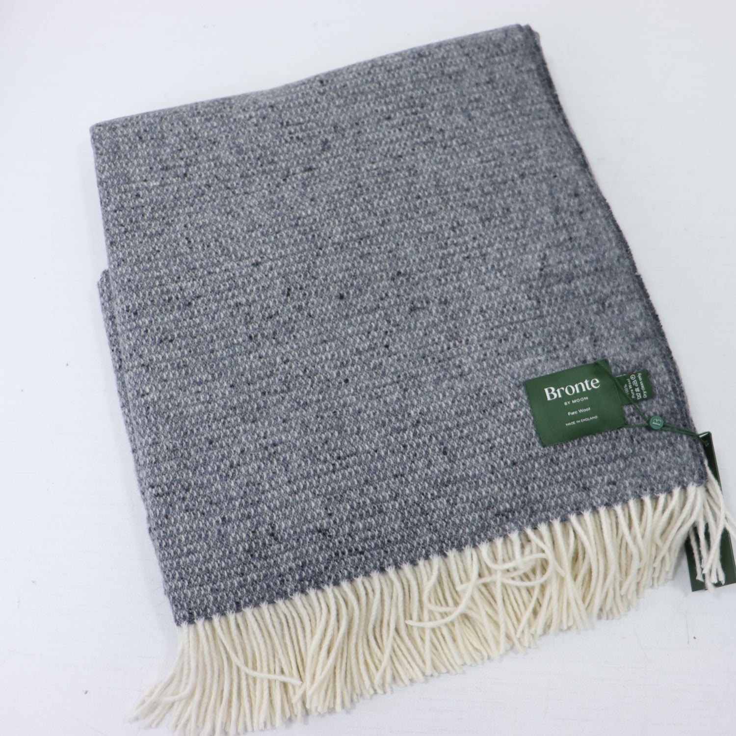 a grey and white blanket with a green tag