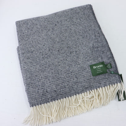 a grey and white blanket with a green tag