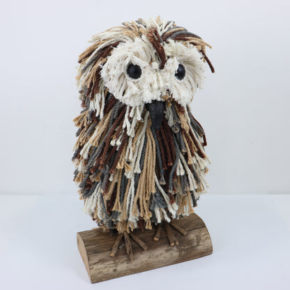 a yarn owl on a wood stand