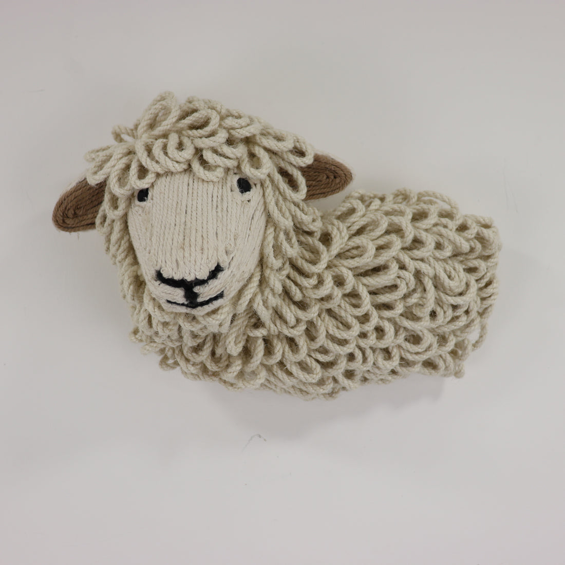 a knitted sheep on a white surface
