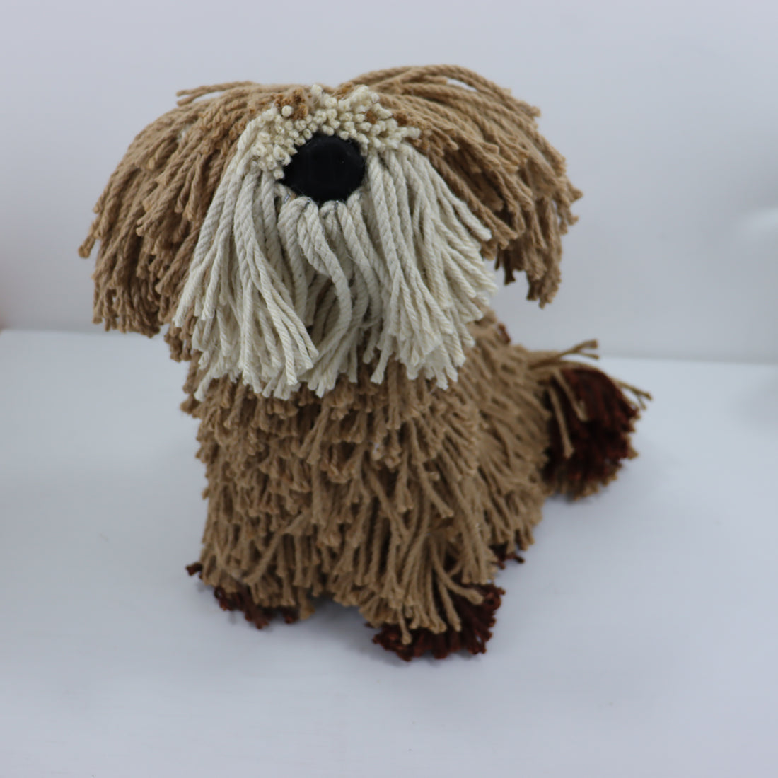 Knitted dog toy with brown and beige fur on a white background