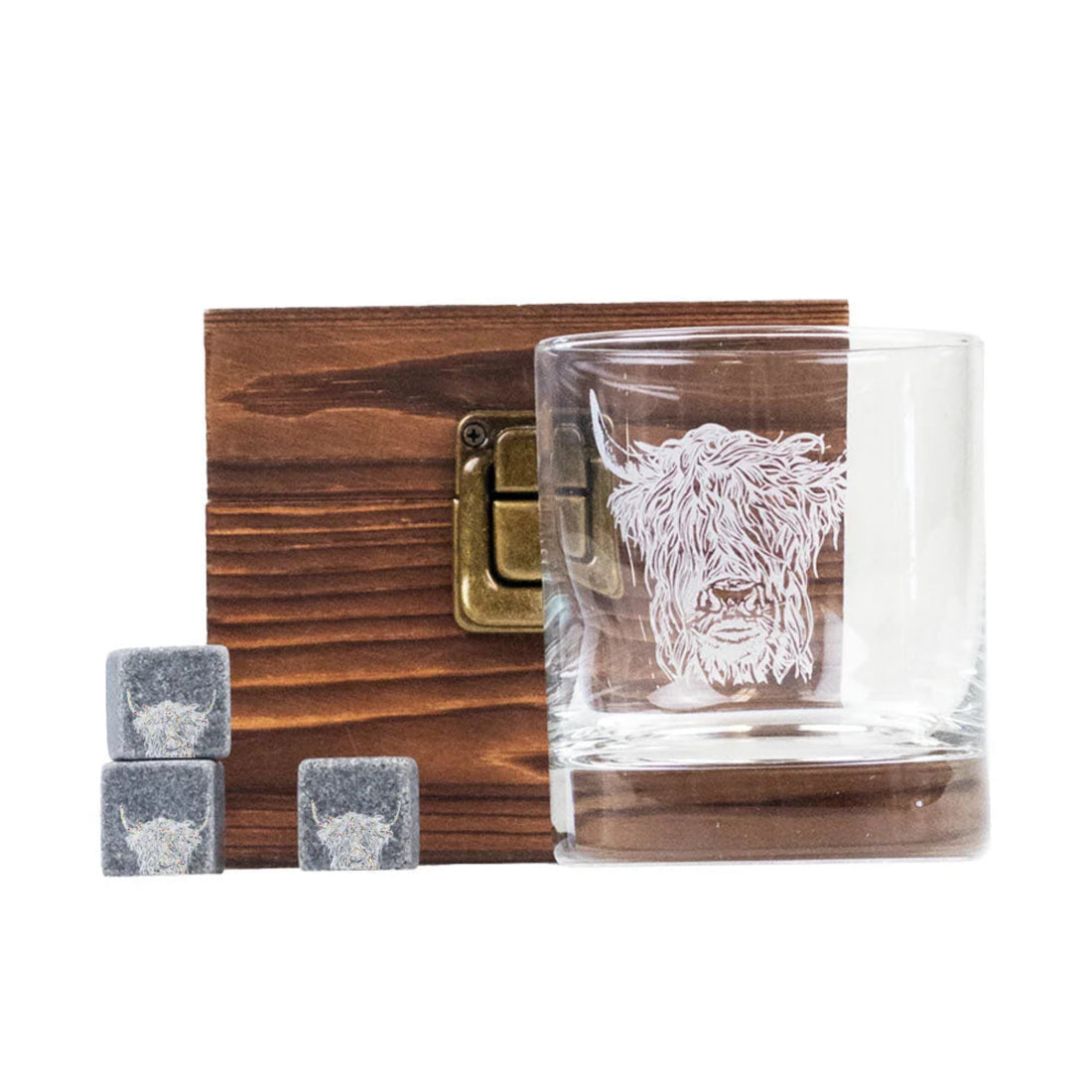 Glass with engraved design, wooden box, and stone cubes on a white background
