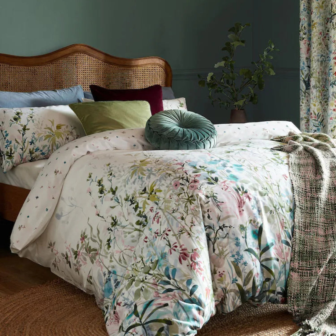a bed with a floral comforter and pillows