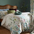 a bed with a floral comforter and pillows