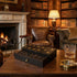 Luxurious living room with leather furniture, bookshelves, and a fireplace.