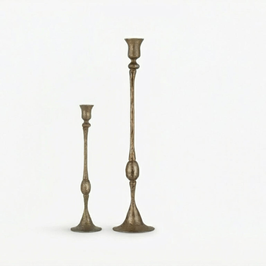 Two tall, ornate candlesticks on a white background