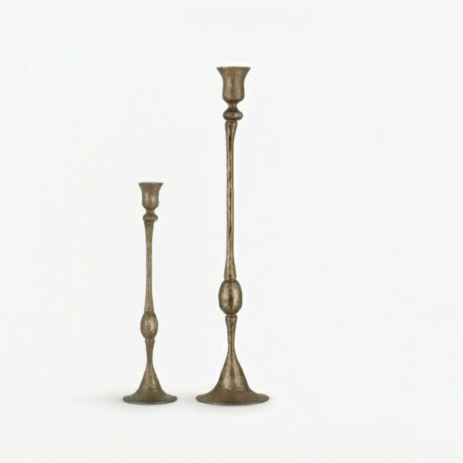 Two tall, ornate candlesticks on a white background