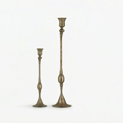 Two tall, ornate candlesticks on a white background